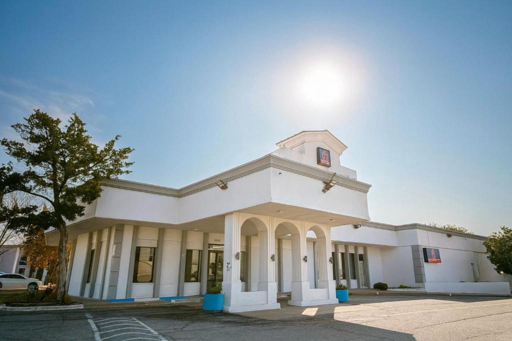 a white building with a tower on top of it at Motel 6 Sherman, TX in Sherman