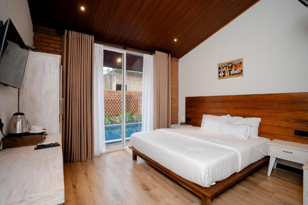 a bedroom with a large white bed and a window at Sunsei Beach Negombo in Negombo