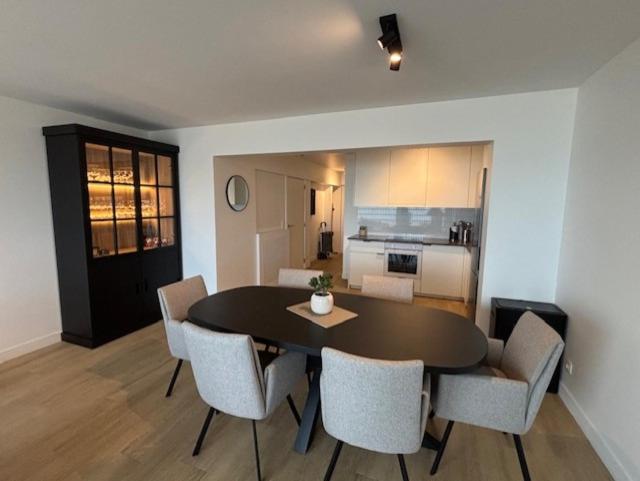 a dining room with a table and chairs and a kitchen at Orion NorthSea Suite in Blankenberge