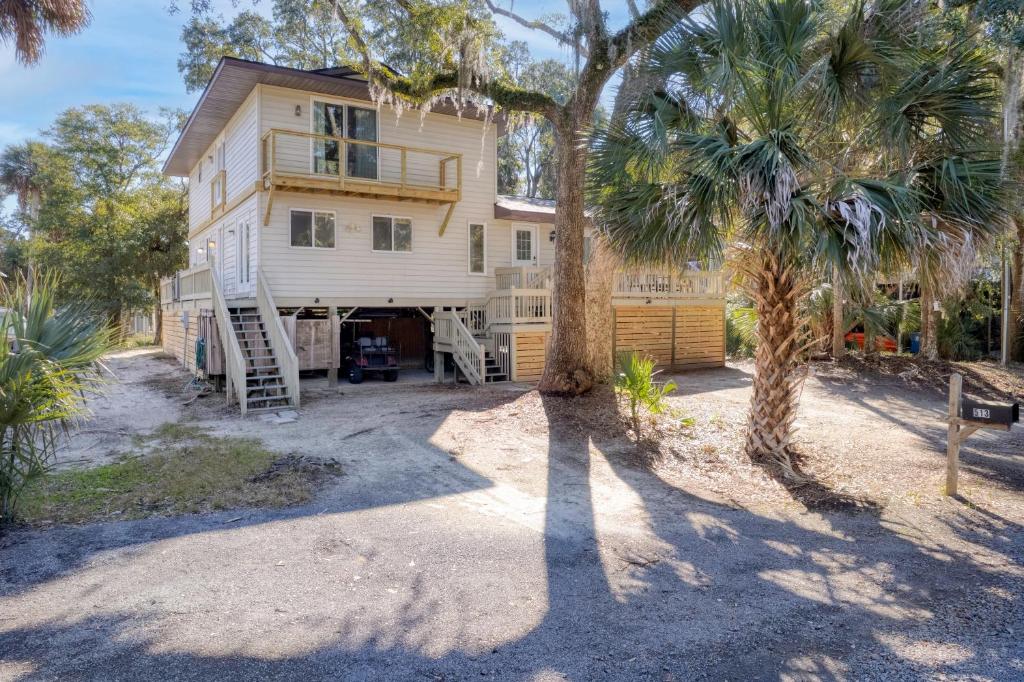 a house with a palm tree in front of it at The Ugly Dolphin a Stylish Home for 12 in Edisto Island