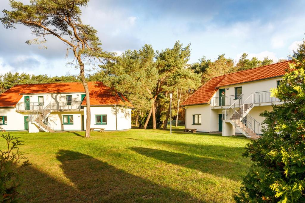 a house with a grassy yard in front of it at Feriendorf Strandgut in Altenkirchen