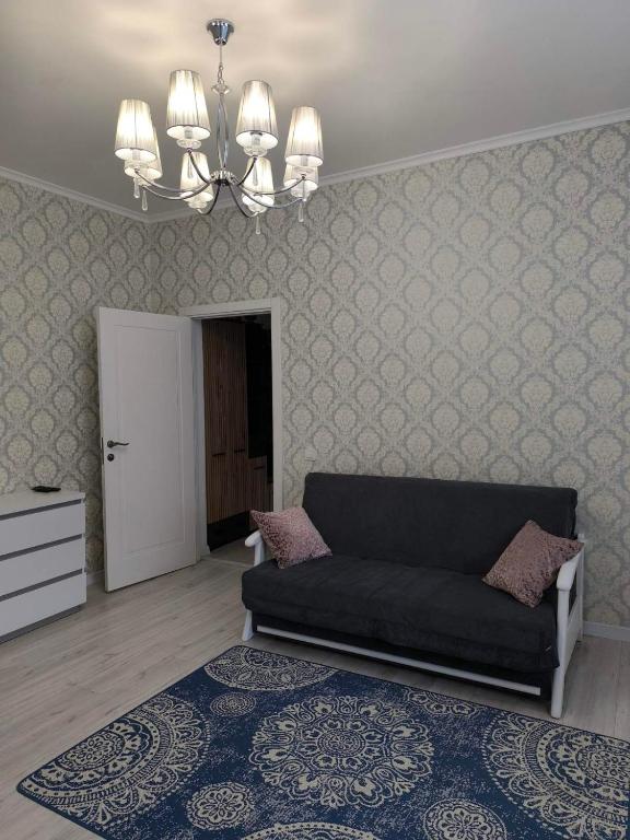 a living room with a couch and a chandelier at Апарт-Отель Rozi in Svalyava
