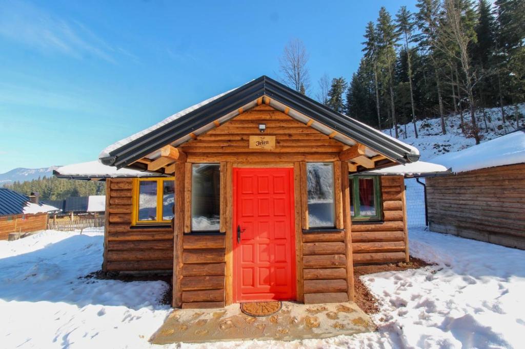 a log cabin with a red door in the snow at Drina in Pale