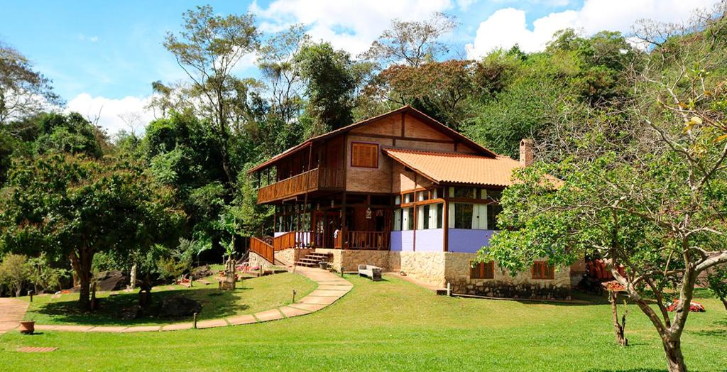a large house in the middle of a park at Pousada Canto do Papagaio in Aiuruoca