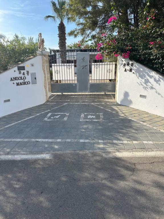 a white fence with a gate and a sidewalk at B&B Angolo Magico in Baia Di Gallipoli