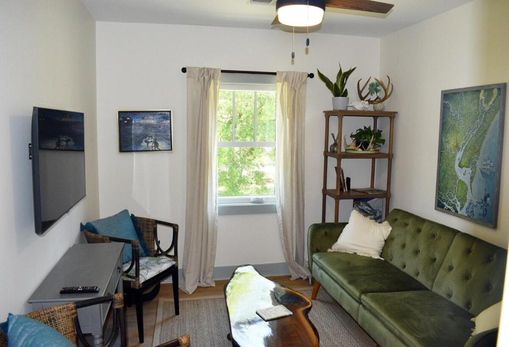 a living room with a green couch and a window at 427 Broad Street in Georgetown