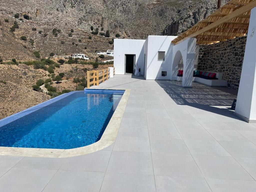 a house with a swimming pool in front of a mountain at Shaunagh's Place in Kalymnos