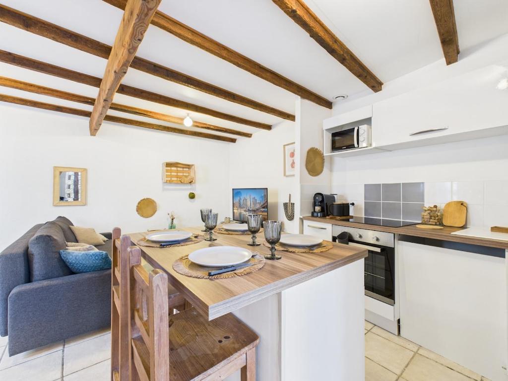 a kitchen and living room with a table and a couch at Le Petit Cocon de Ambre in Saint-Paul