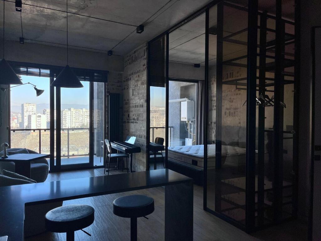 a room with a bed and some stools in it at Designer View Vake in Itʼkhvisi