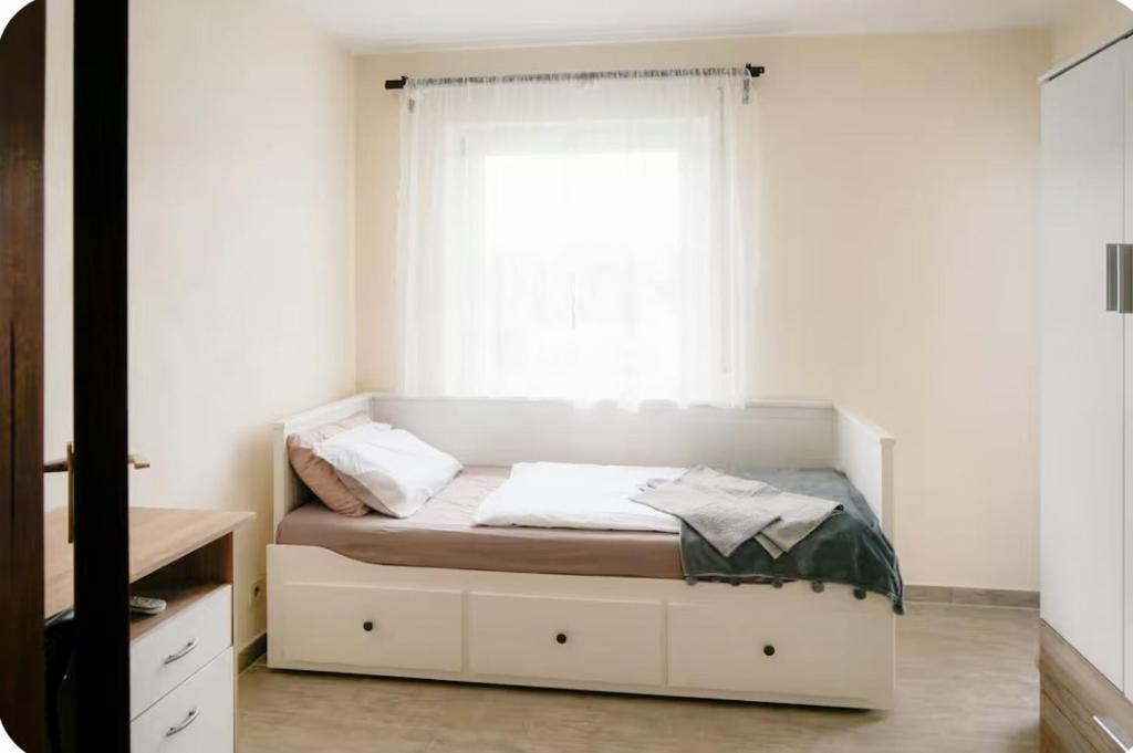 a small bedroom with a bed with a window at Zimmer mit Balkon im Stuttgart Flughafen Messe in Ostfildern