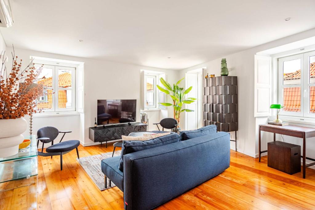 a living room with a blue couch and a table at Boutique duplex in Chiado with epic Rossio view in Lisbon