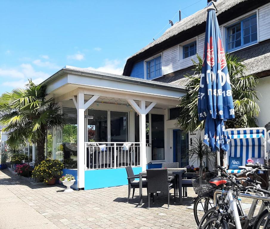 a restaurant with a table and chairs and umbrellas at Landhotel Ostseetraum & Apartments in Warnemünde
