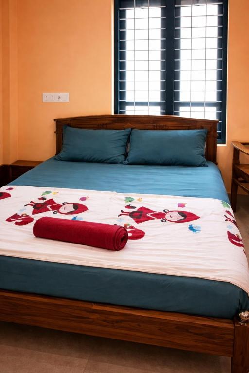 a bed with a blanket with flowers on it at Casa Tangerina in Varkala