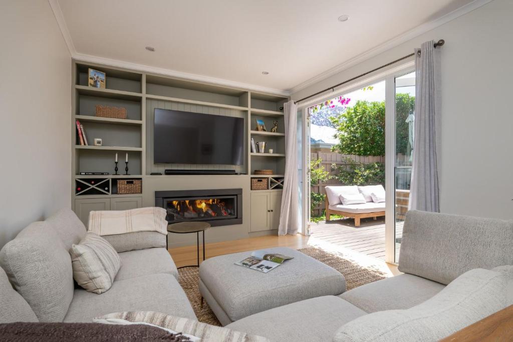 a living room with a couch and a fireplace at Evergreen by the Bay in Sandringham