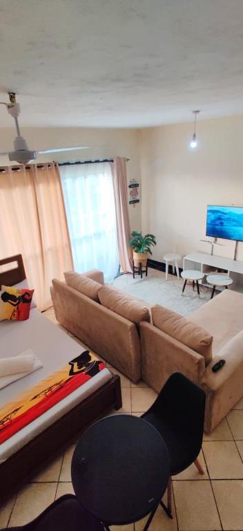 a living room with a couch and a table at Shanzu Studio Stamford Apartment in Mombasa