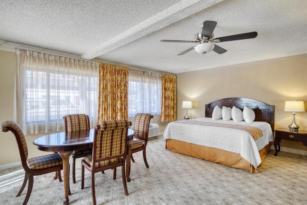 a bedroom with a bed and a table and chairs at SureStay Plus Hotel by Best Western Reno Airport in Reno