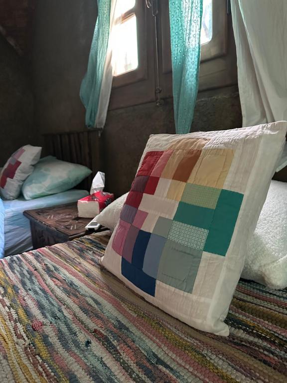 a bedroom with a bed with a colorful quilt on it at Maison Nassimah in Giza