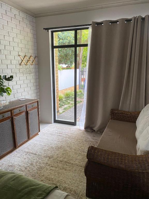 a living room with a sliding glass door to a patio at The Cozy Acre Unit 2 in Potchefstroom