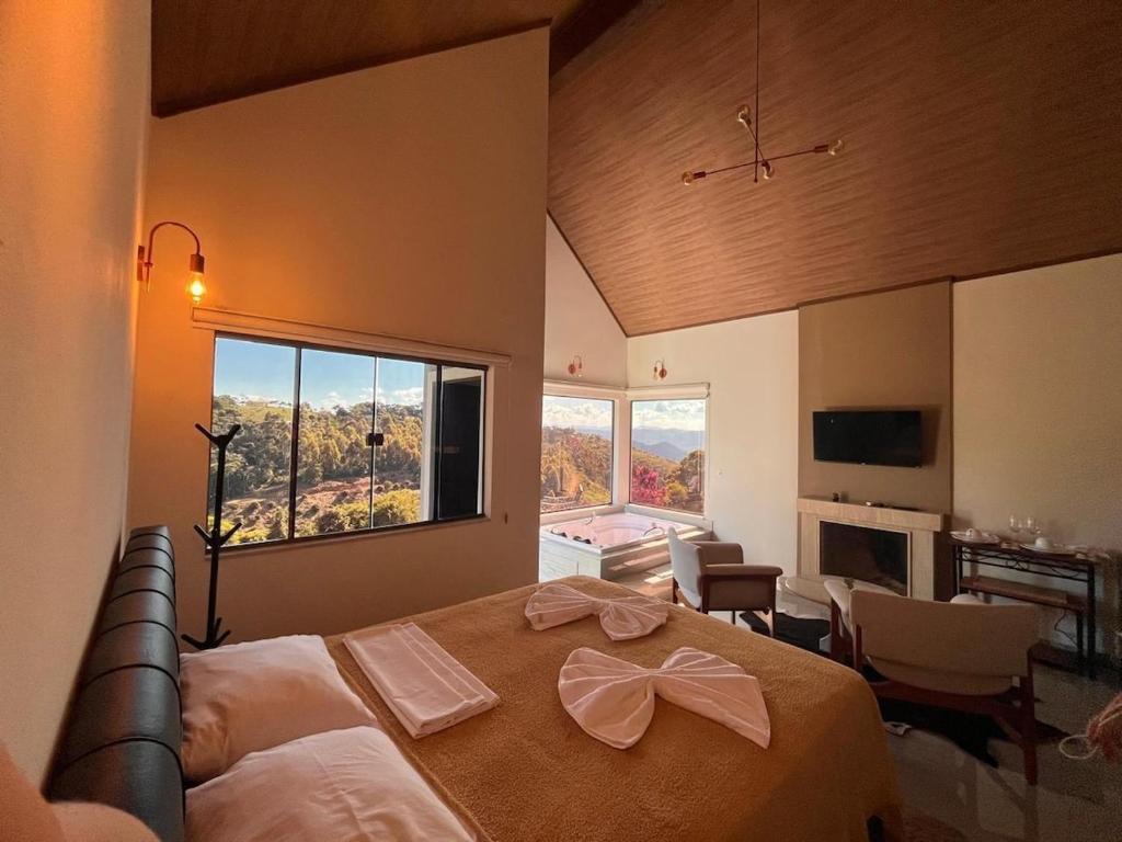 a bedroom with a large bed and a large window at Chalé Bella Vista 03 in Água Boa