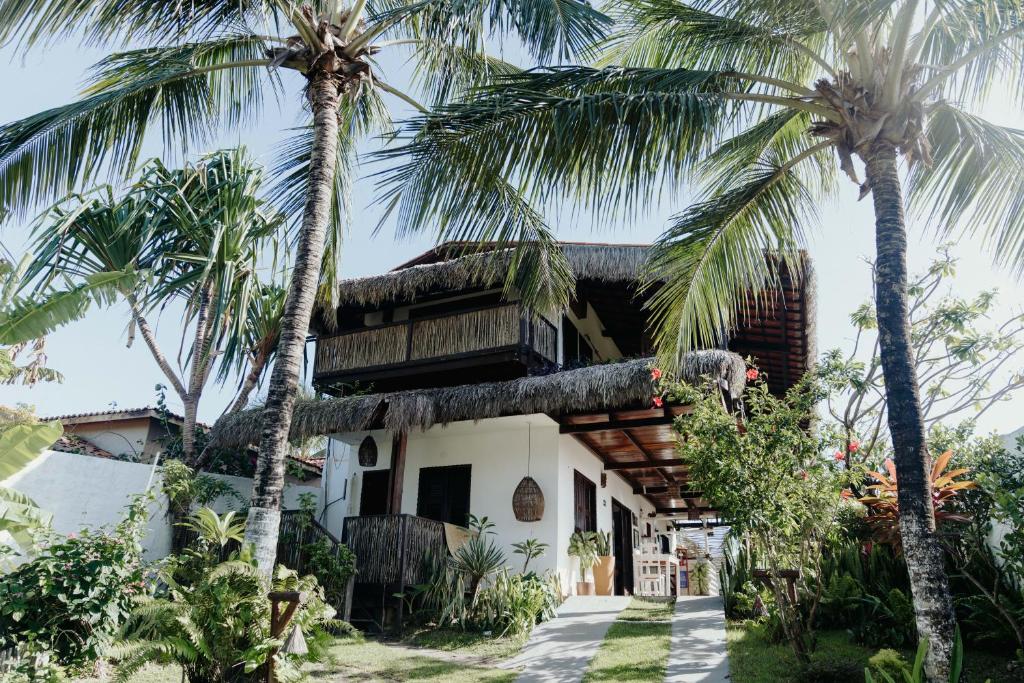 a house with palm trees in front of it at Pousada Brisa Del Mar in Icaraí