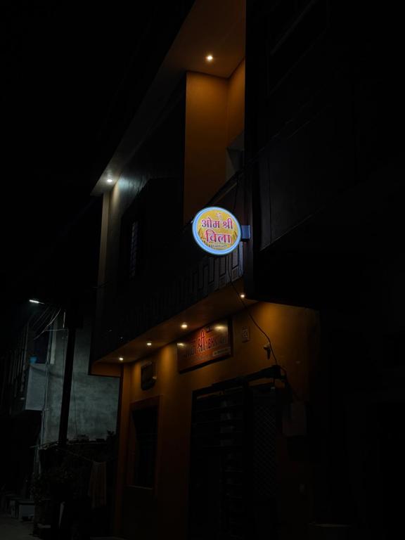 a sign on the side of a building at night at Omshree hotel in Ujjain