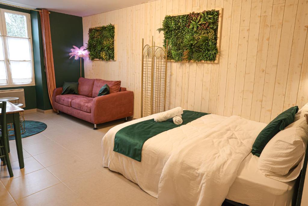 Un dormitorio con una cama, un sofá y una silla. en Le Studio Vert, en La Flèche