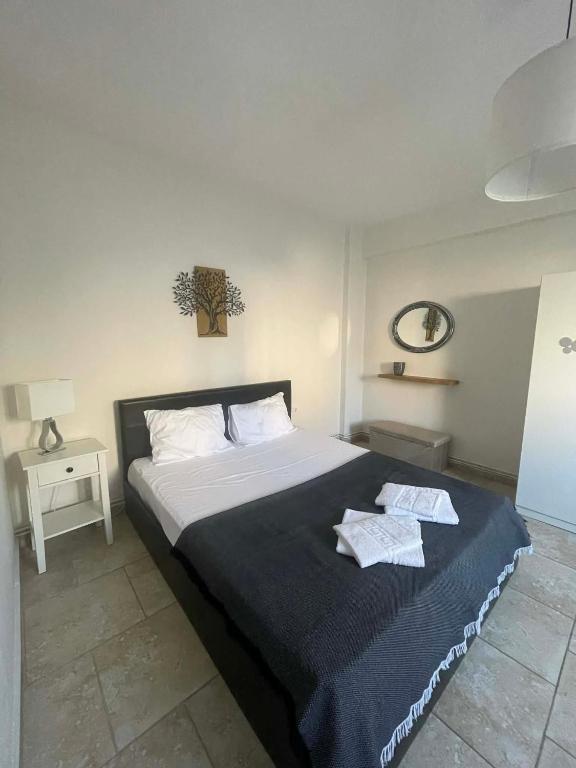 a bedroom with a large bed with two towels on it at Apartment Akanthous in Kallithea Halkidikis
