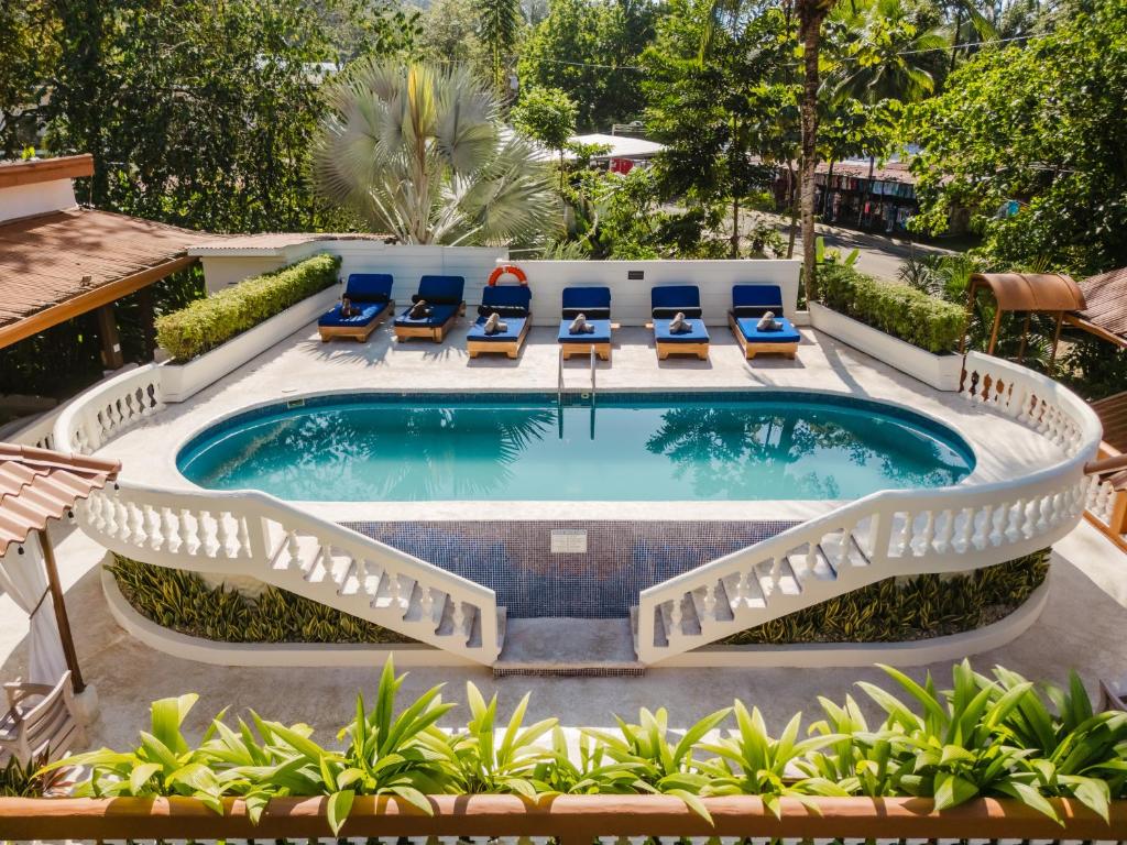a swimming pool with lounge chairs and a patio with a swimming poolvisor at Hotel Villabosque Eco Boutique in Manuel Antonio