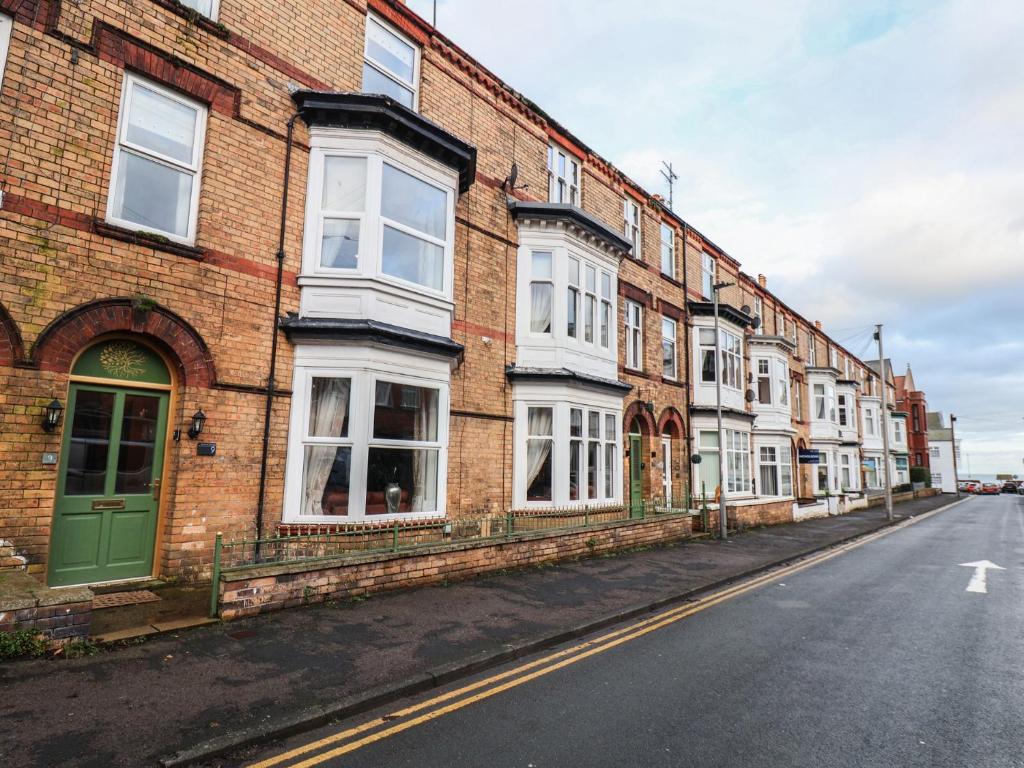 a row of brick buildings on a street at Rutland Grange in Filey
