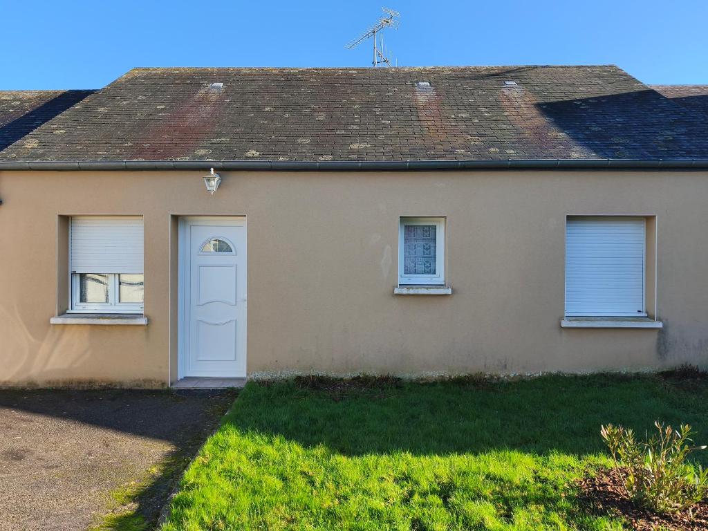 a house with a white door and windows at Pavillon in Saint-Berthevin-sur-Vicoin