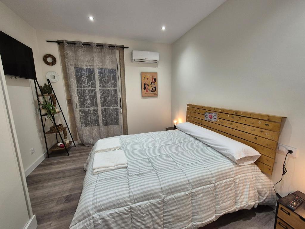 a bedroom with a large bed and a window at Escola in Ourense