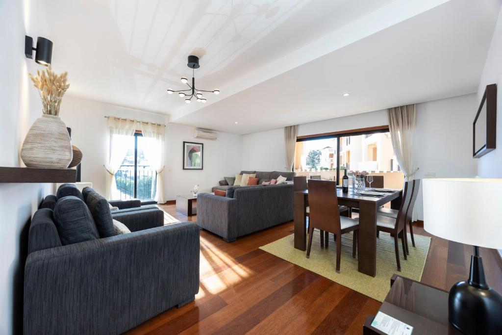 a living room with couches and a dining room at Luz Beach Luxury Apartment in Luz
