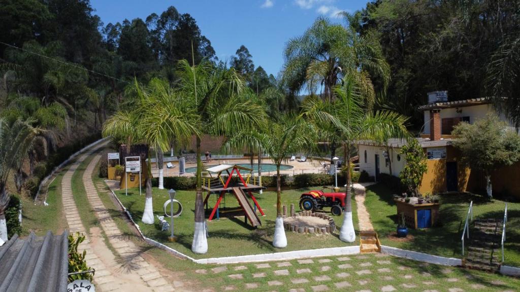 a park with a playground with palm trees at Recanto dos Carvalhos - Pousada Camping in São Lourenço