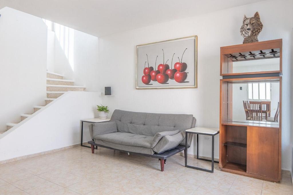 a living room with a chair and a picture of apples at Casa completa con alberca en Chetumal in Chetumal