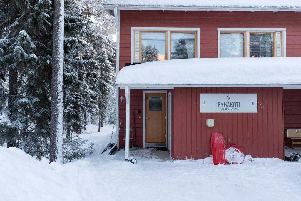 a red building in the snow with a red fire hydrant at Pyhäkoti A - 30 Meters From the Slopes - Valkea Homes in Pyhätunturi