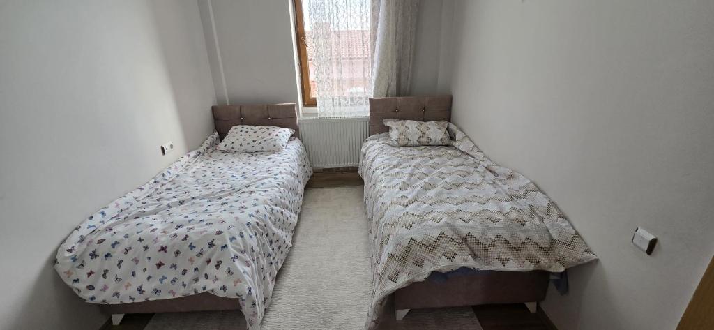 two twin beds in a room with a window at Onur Termal in İhsaniye