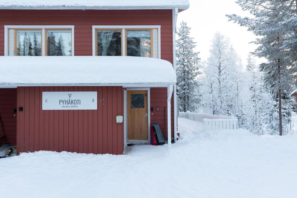 a red house in the snow with a sign that reads trinity at Pyhäkoti D - 30 Meters From the Slopes - Valkea Homes in Pyhätunturi