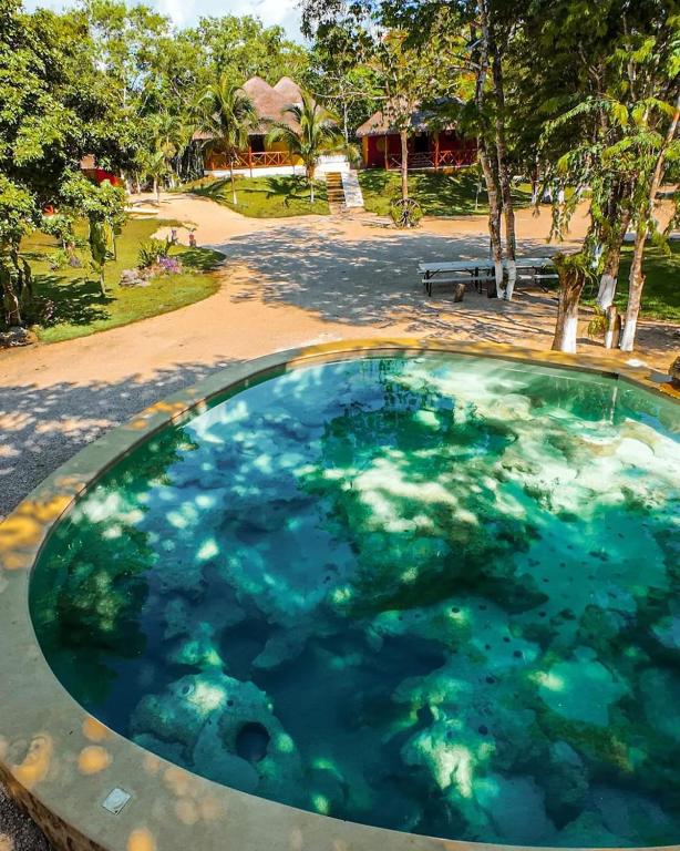 a large pool of blue water in a park at Hotel Aldea Cruzo'ob in Felipe Carrillo Puerto