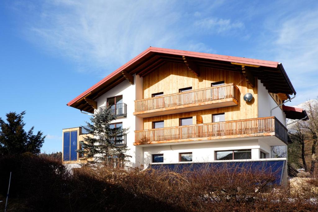 a building with a balcony on top of a hill at Haus Gerti in Ramsau am Dachstein