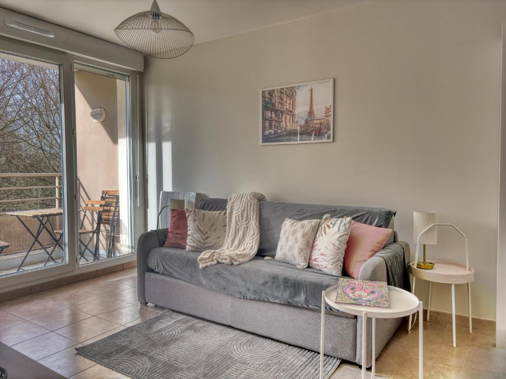 a living room with a couch and a table at Parisian escape near Disney - Liz Appart in Montévrain