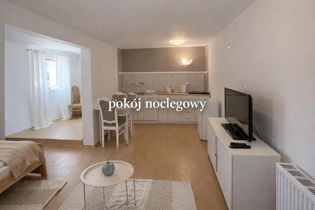 a living room with a couch and a tv and a kitchen at Pokój noclegowy in Józefowo