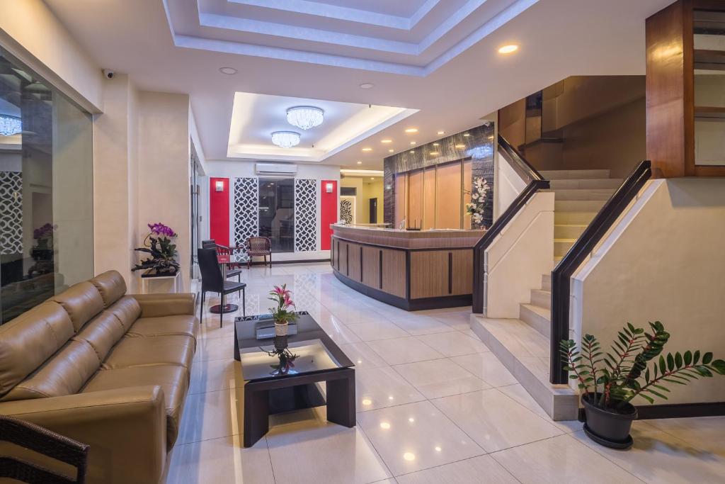 vestíbulo con sofá, mesa y escaleras en Asia Stars Hotel en Tacloban