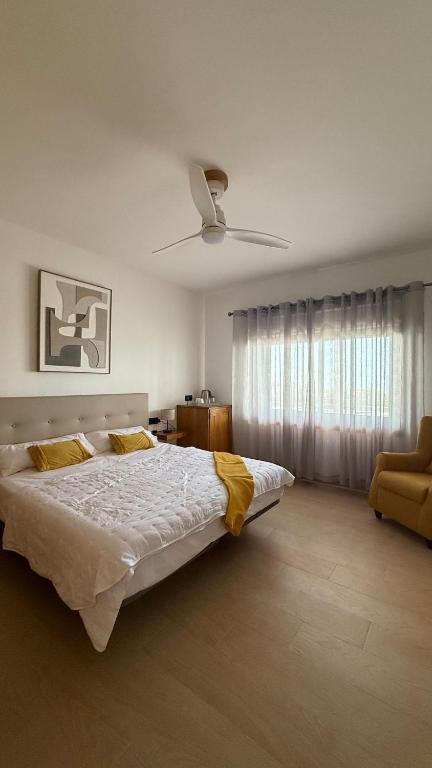 a bedroom with a large bed and a ceiling fan at Yellow Room - Sunlite Double Private Room in Villa Barbuja in Tefía