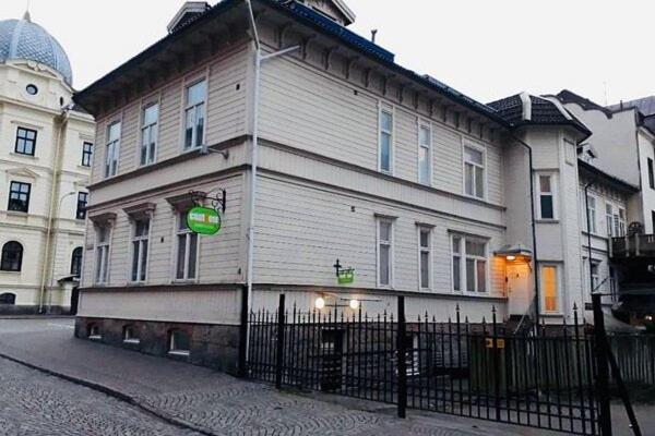 a large white building with a fence in front of it at CentRum turistlogi in Borås