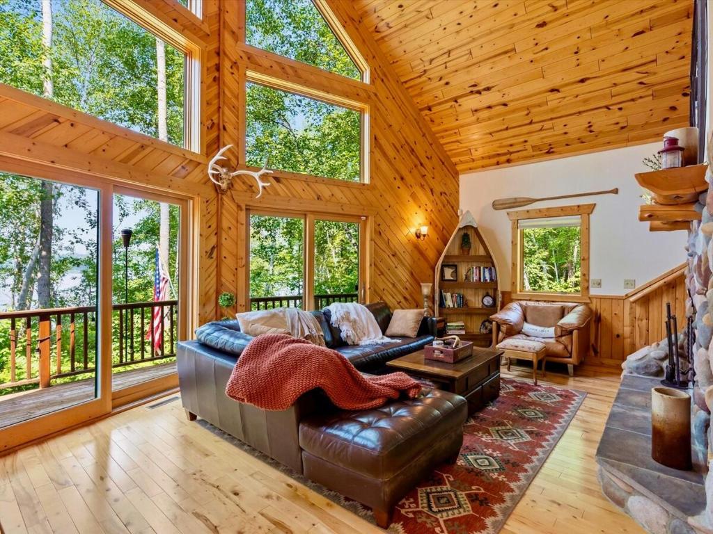 a living room with a leather couch and a table at Sunset Serenity on Kego Lake in Fifty Lakes
