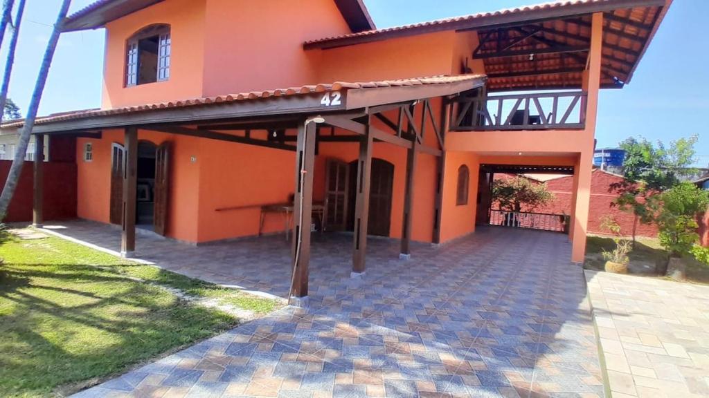 an orange house with a walkway in front of it at Sobrado em Coroados, Guaratuba PR in Guaratuba