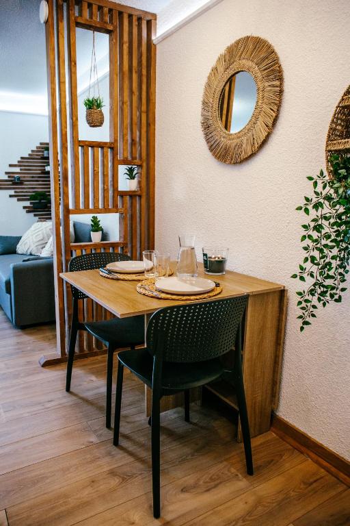 a dining room table with chairs and a mirror at La Canopée Jurassienne in Les Rousses