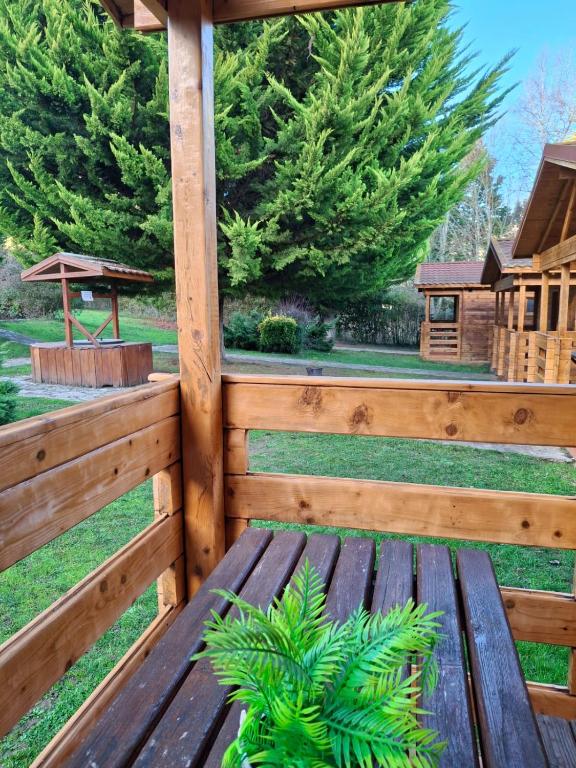 a wooden bench in a fence with a gazebo at La Cabaña Rural in Paúl
