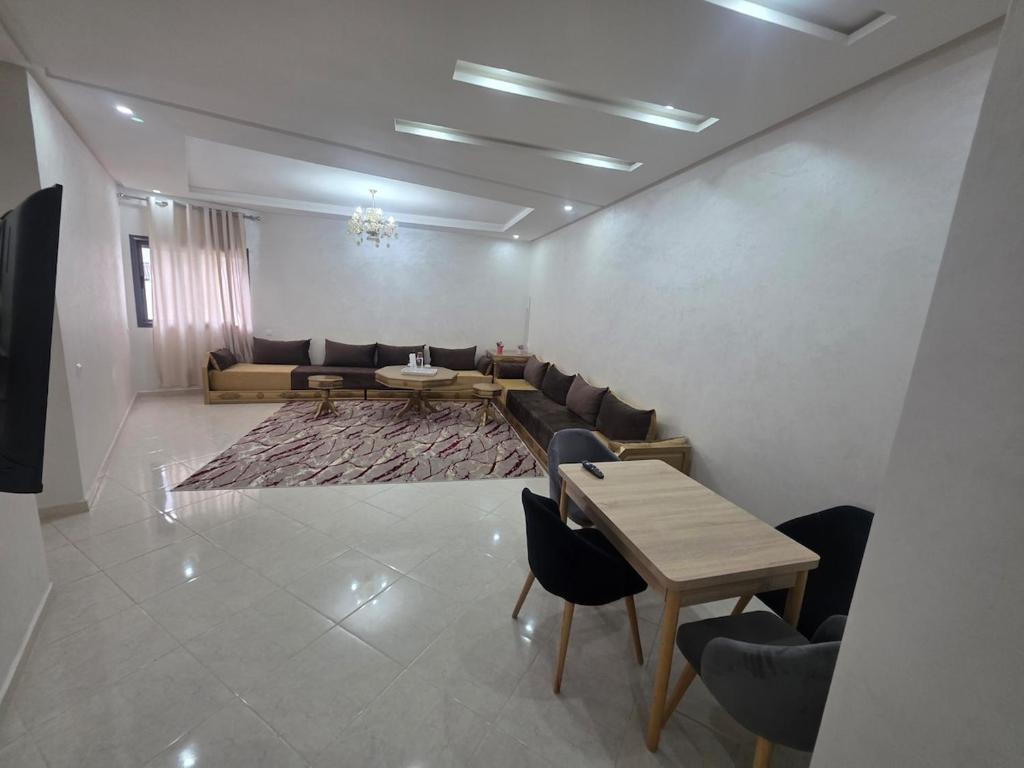 a room with a couch and a table and chairs at Massira Green Park Serenity in Kenitra