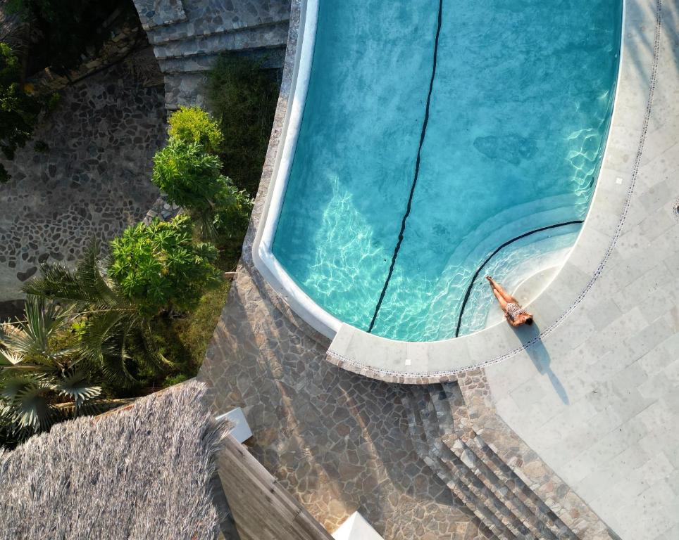 an overhead view of a swimming pool with a person in the water at Zazil Retreat in San Agustinillo